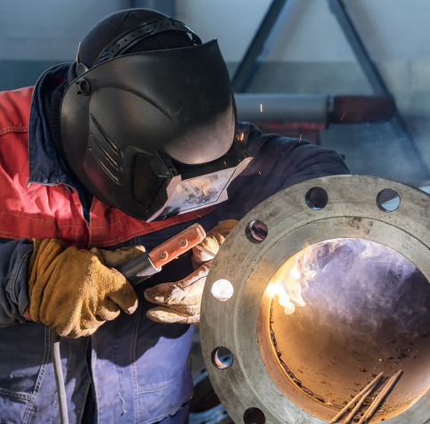 Man welding a flange onto a steel pipe